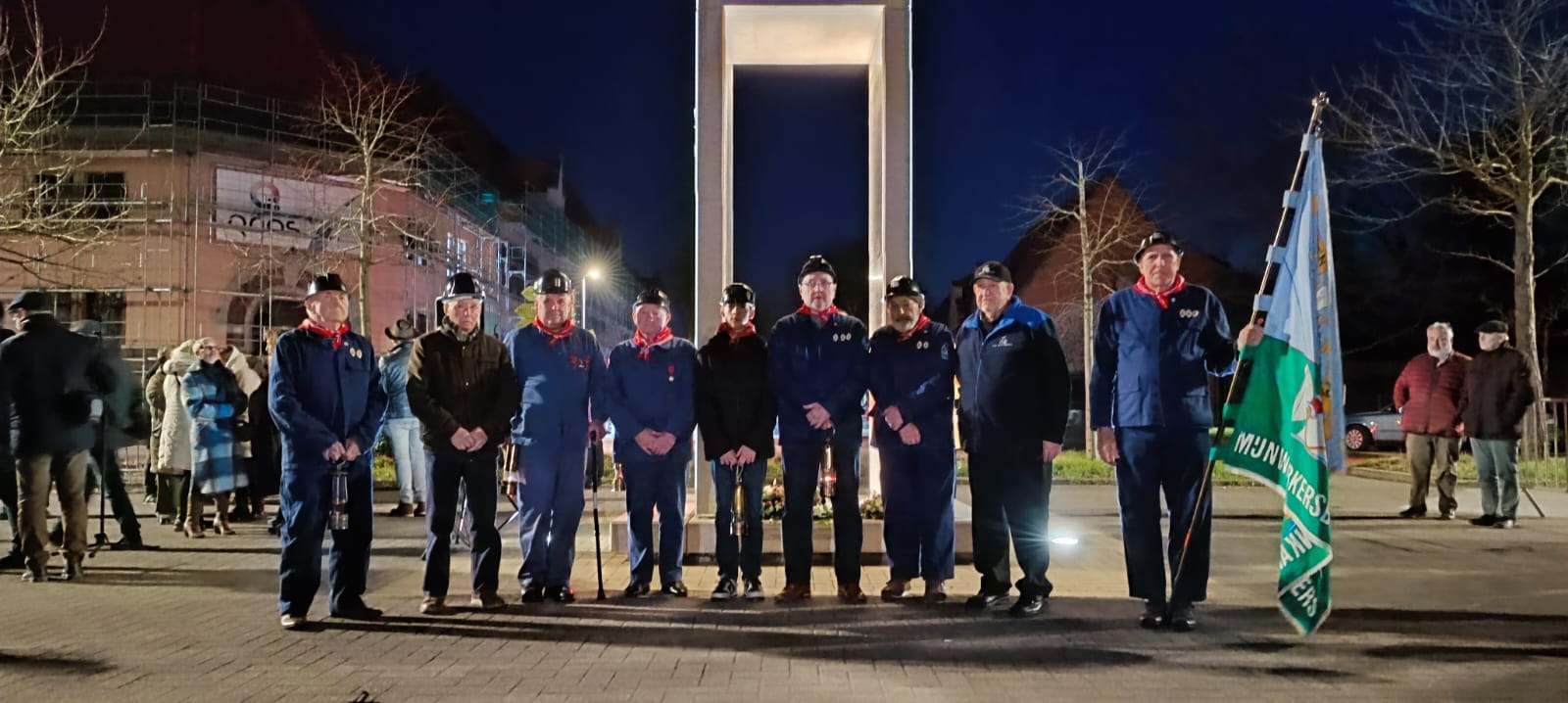 Enkele ex-mijnwerkers voor het monument van de verongelukte mijnwerkers.
