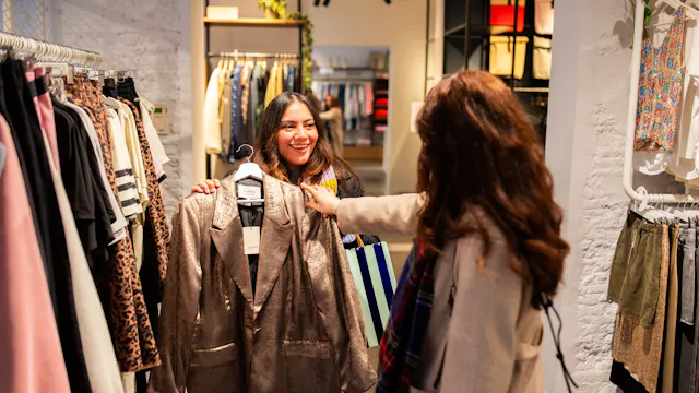 twee dames shoppen kledij in een winkel