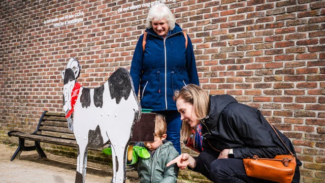 spel kind melkt een koe
