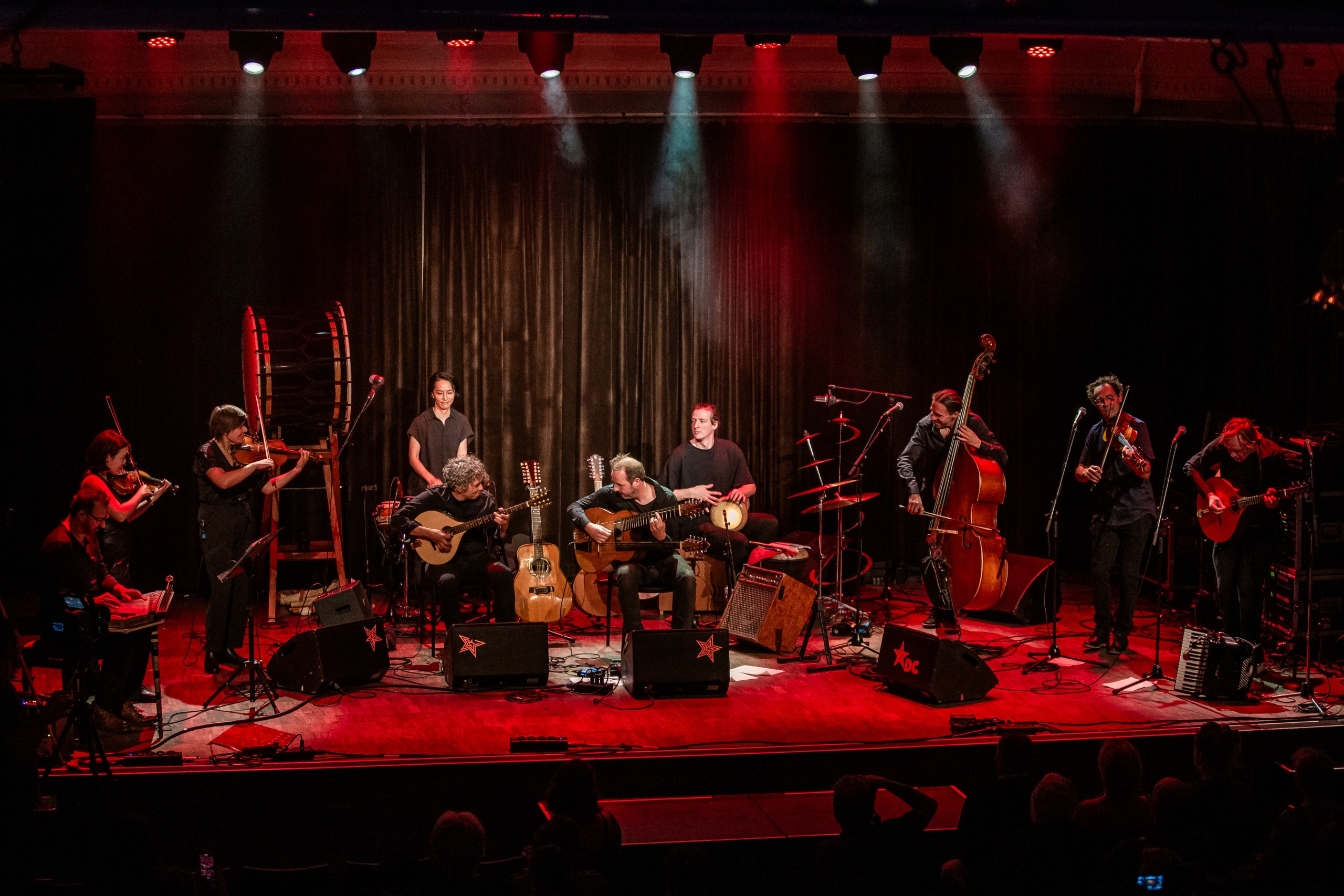 Een live muziekoptreden met meerdere muzikanten op het podium.