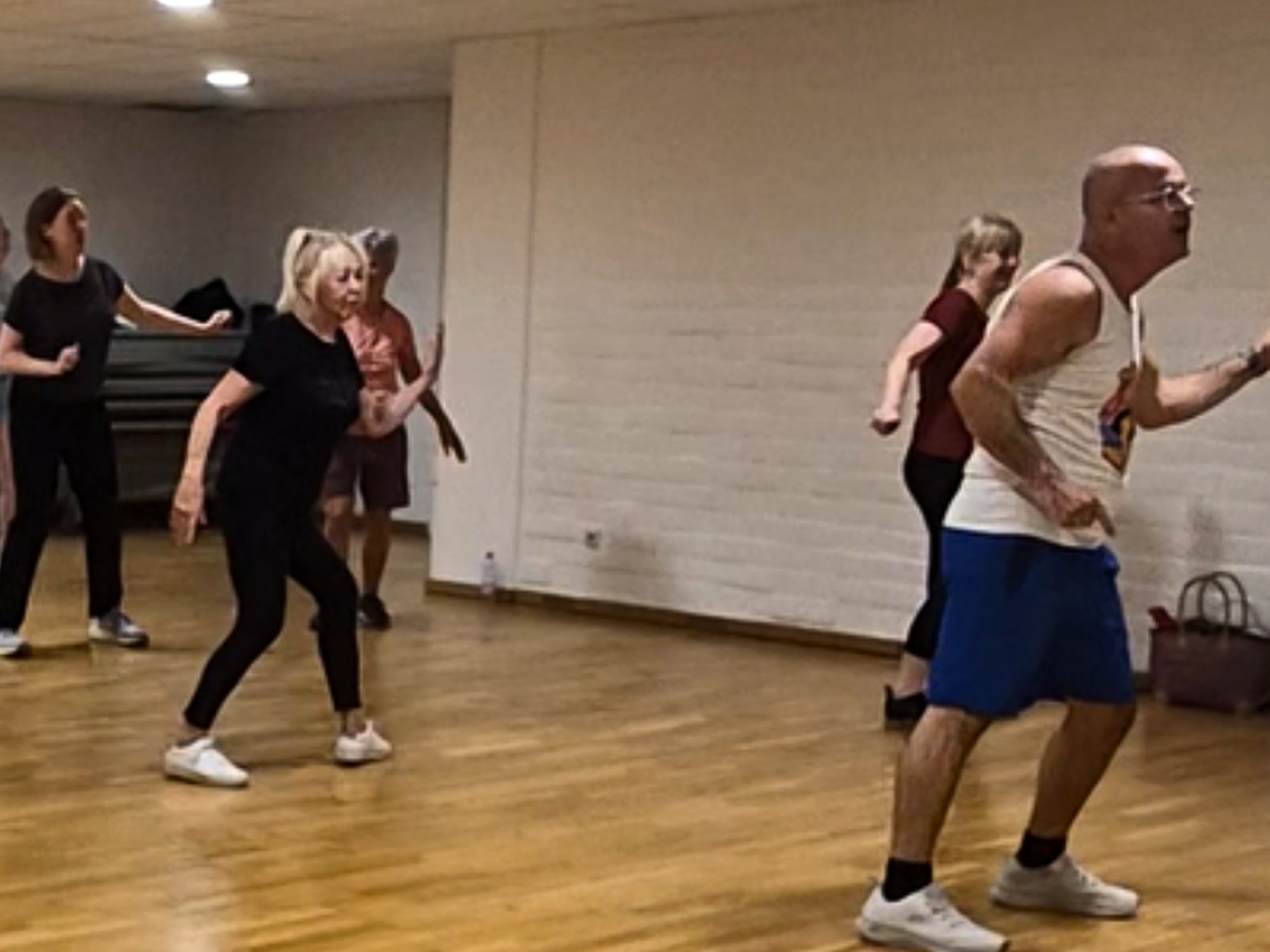 “Low-impact disco-fitness in Leuven: volwassenen bewegen met een glimlach op 70s/80s classics. Vriendelijk tempo, toegankelijk voor alle niveaus. Foto uit sessie in Sportcomplex Kessel-lo