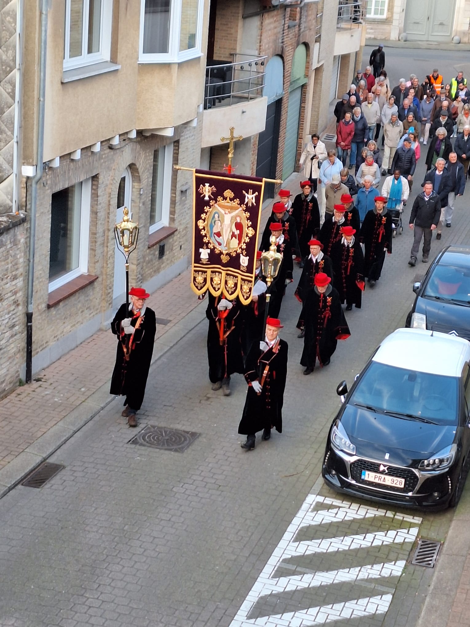 De kruisweg stapt door het avondlijke centrum van Veurne