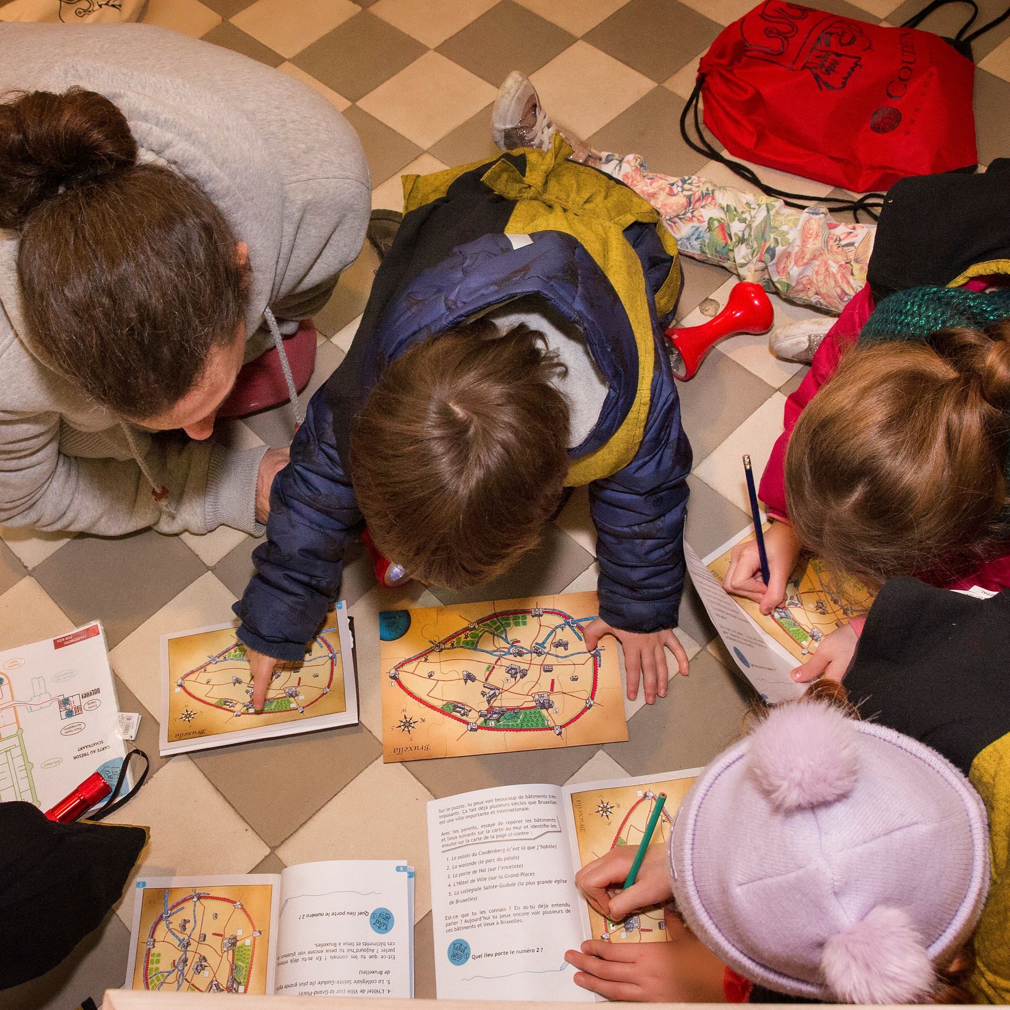 Gezin gebogen over schatkaarten en invulboekjes