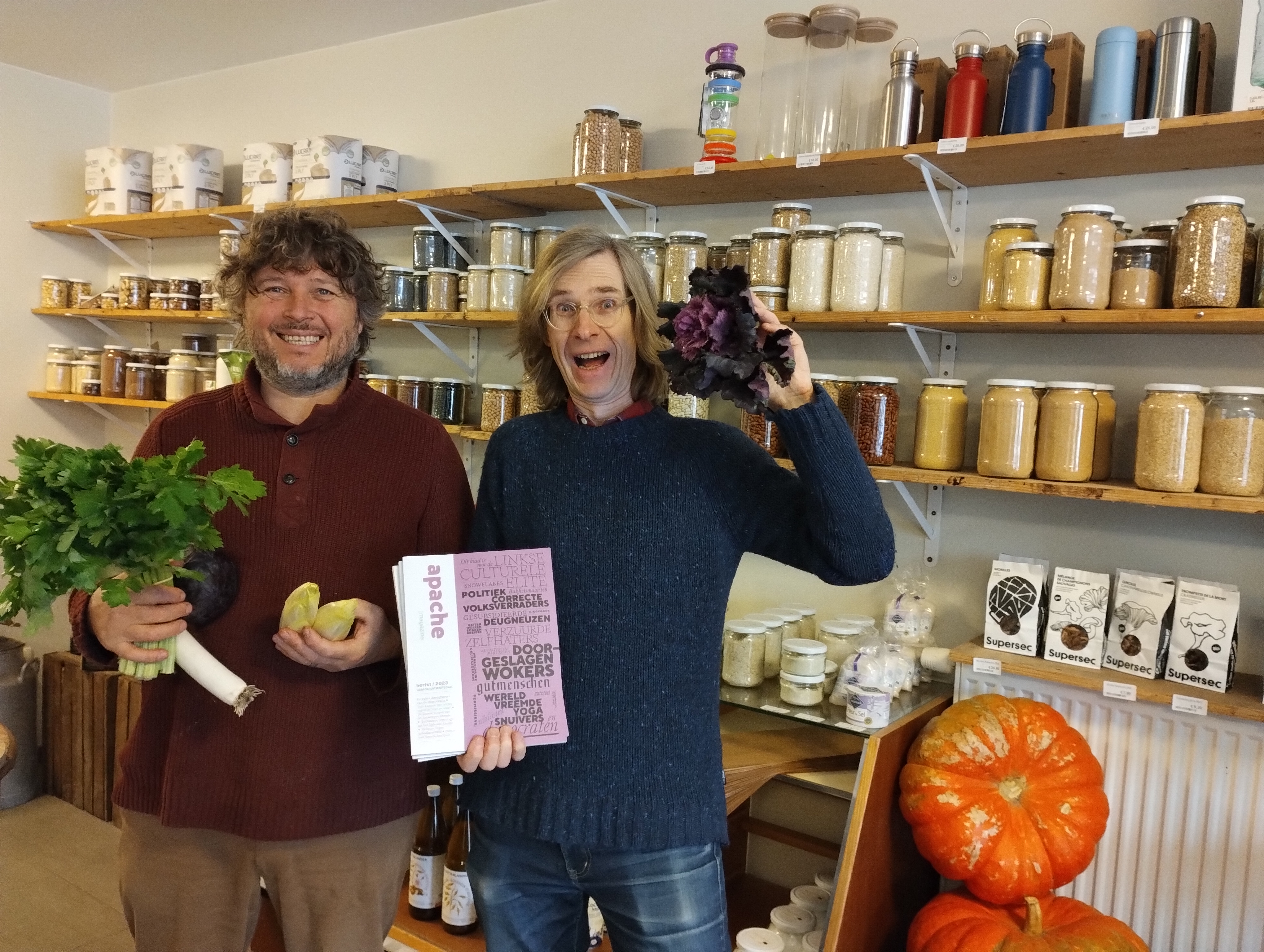 Winkeliers Wim & Wouter in de winkel voor een rek met gevulde potten