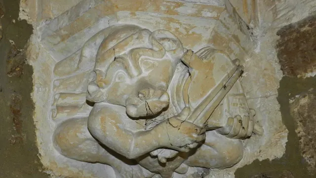 Kraagsteen in de Sint-Sulpitiuskerk met afbeelding van een aap die 'viool speelt' op een blaasbalg