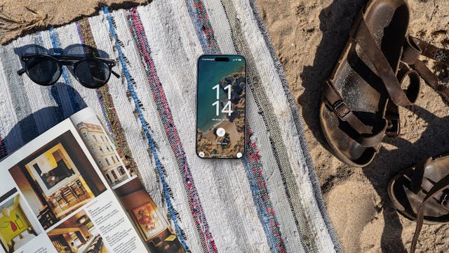 Laken in het strand met tijdschrift, zonnebril, smartphone en sandalen
