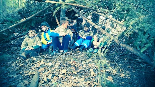 Foto van kinderen die spelen in een kamp in het bos.