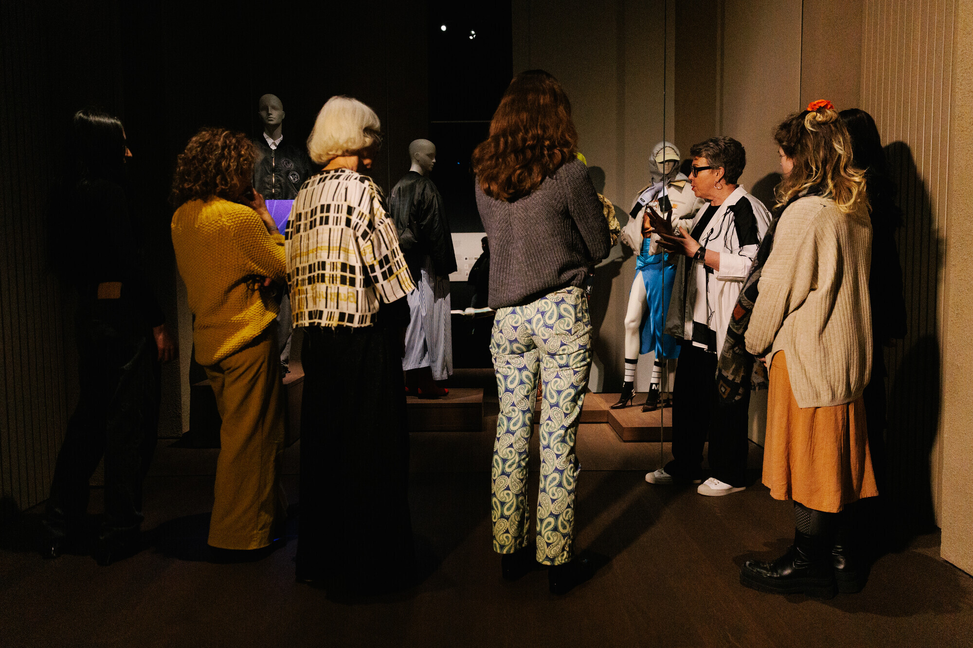 Gids vertelt aan een groep over een silhouet in de MoMu tentoonstelling