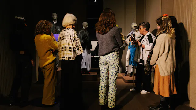 Gids vertelt aan een groep over een silhouet in de MoMu tentoonstelling