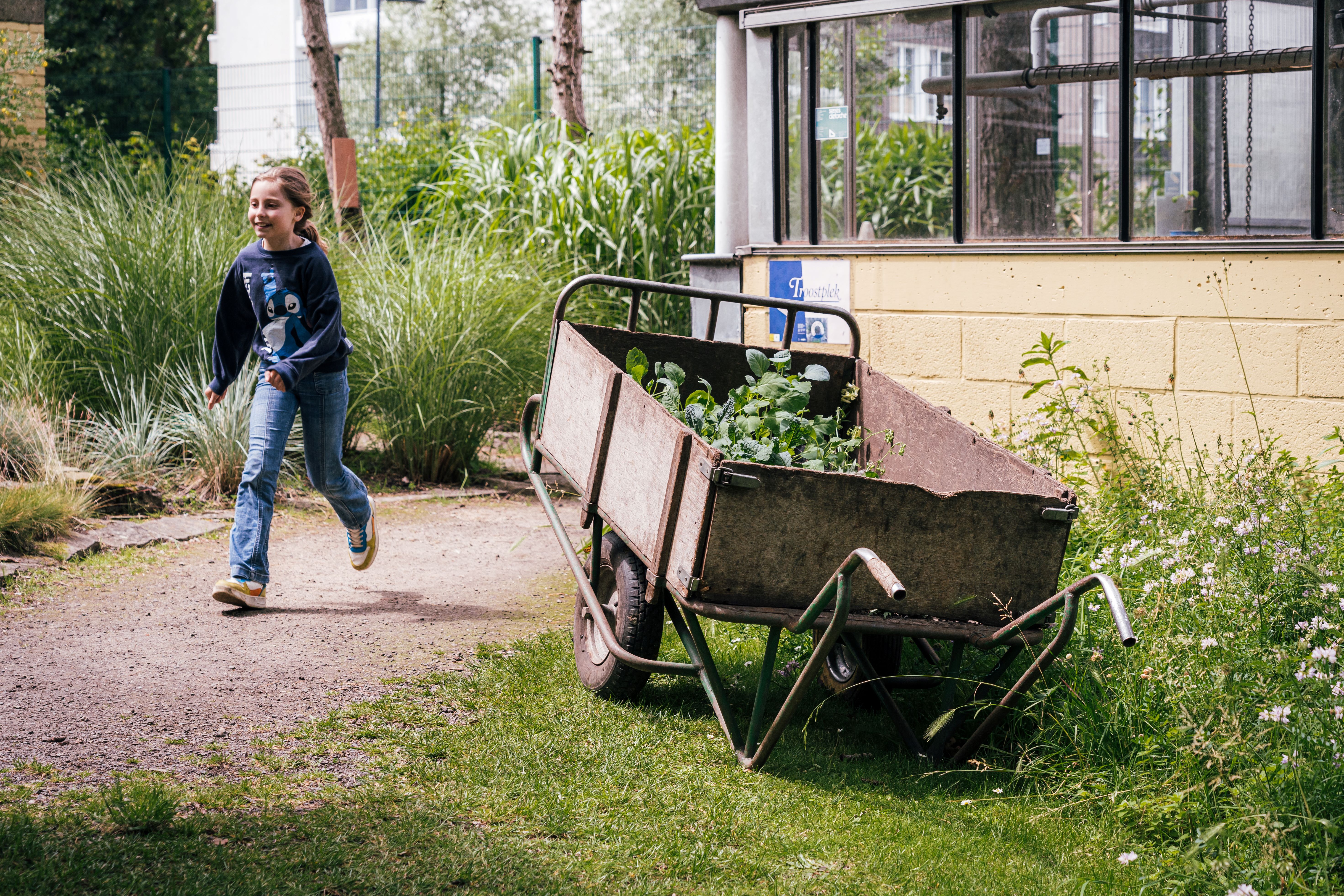 Een meisje loopt in de plantentuin van Kina