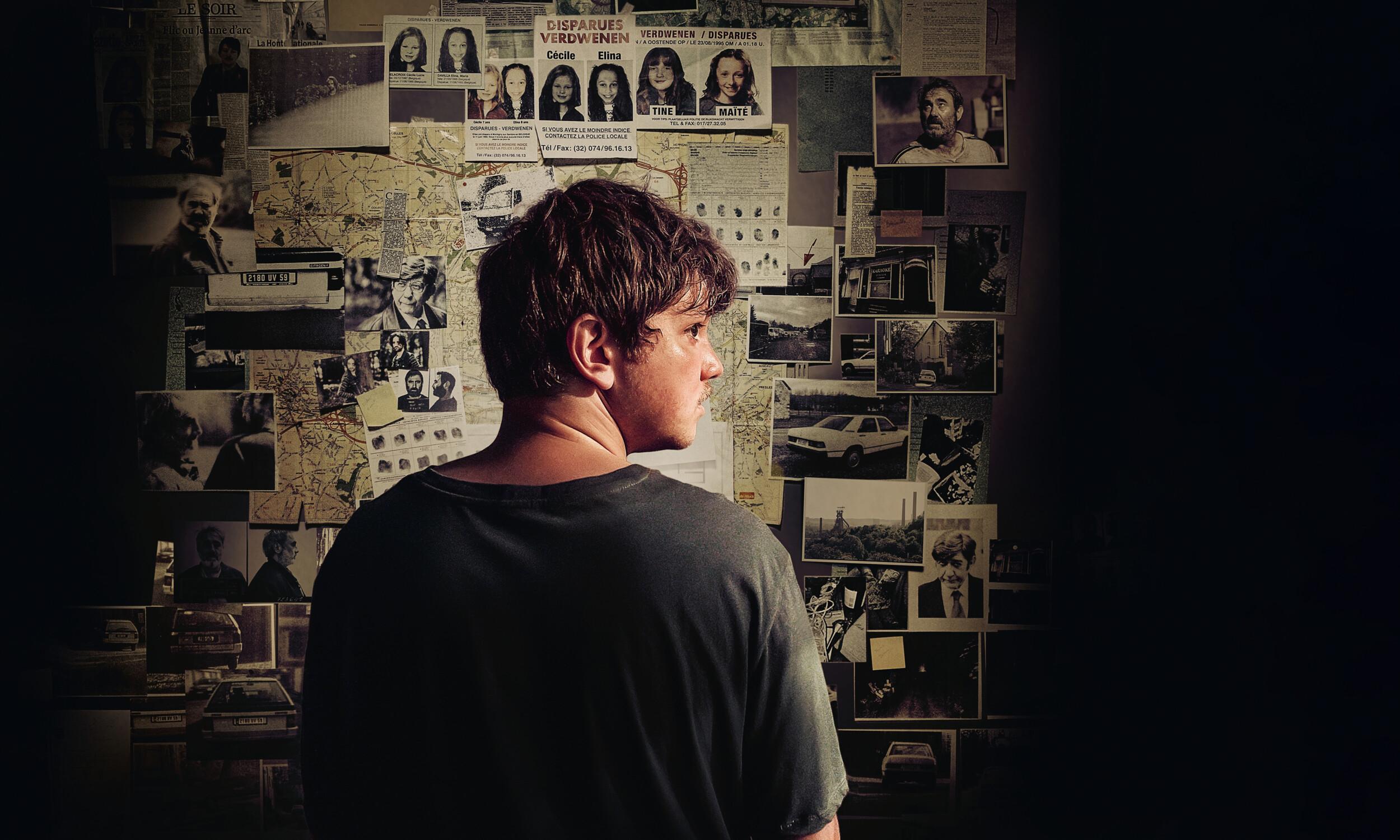 Een man kijkt naar een muur vol foto's en kaarten, die verbanden tonen.