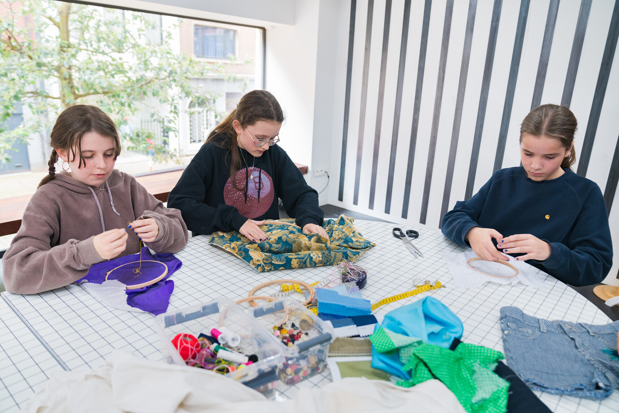 Kinderen borduren, naaien en knippen in de MoMu Studio