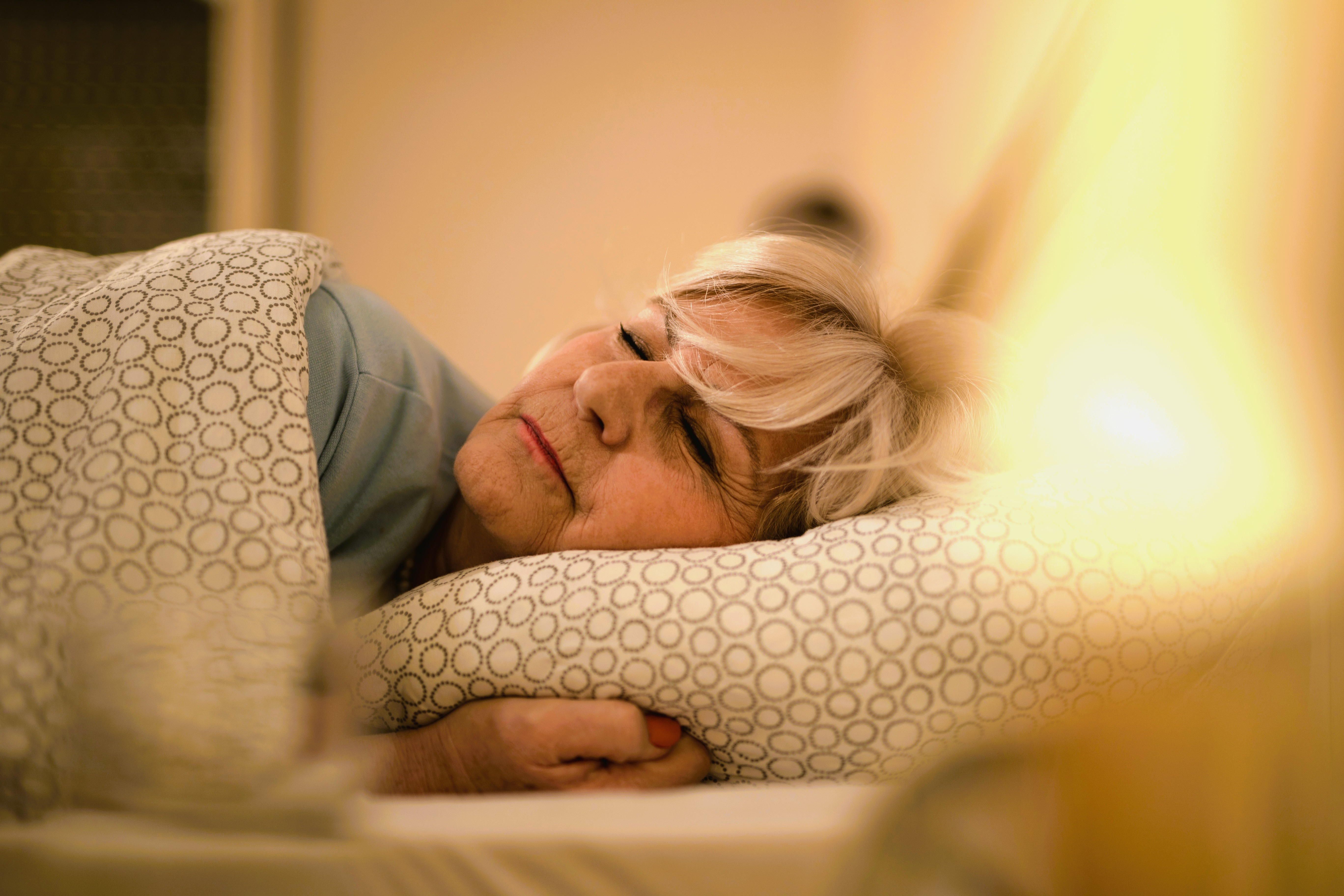 Vrouw ligt te slapen in bed.