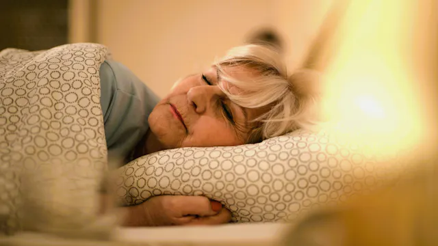 Vrouw ligt te slapen in bed.