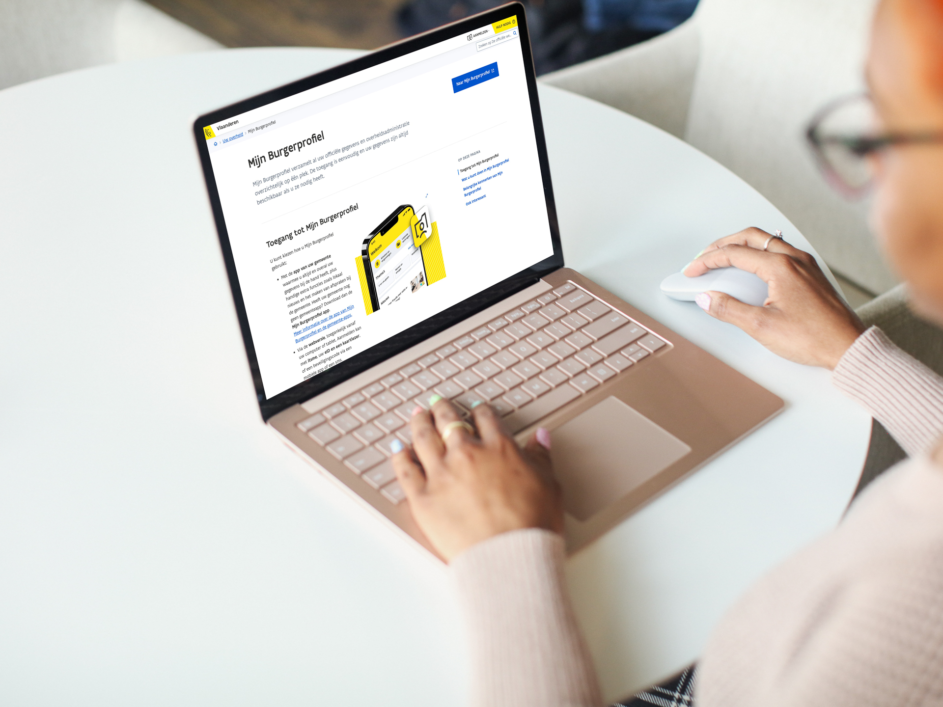 Persoon aan een laptop waarop het toegangsscherm van Mijn Burgerprofiel te zien is