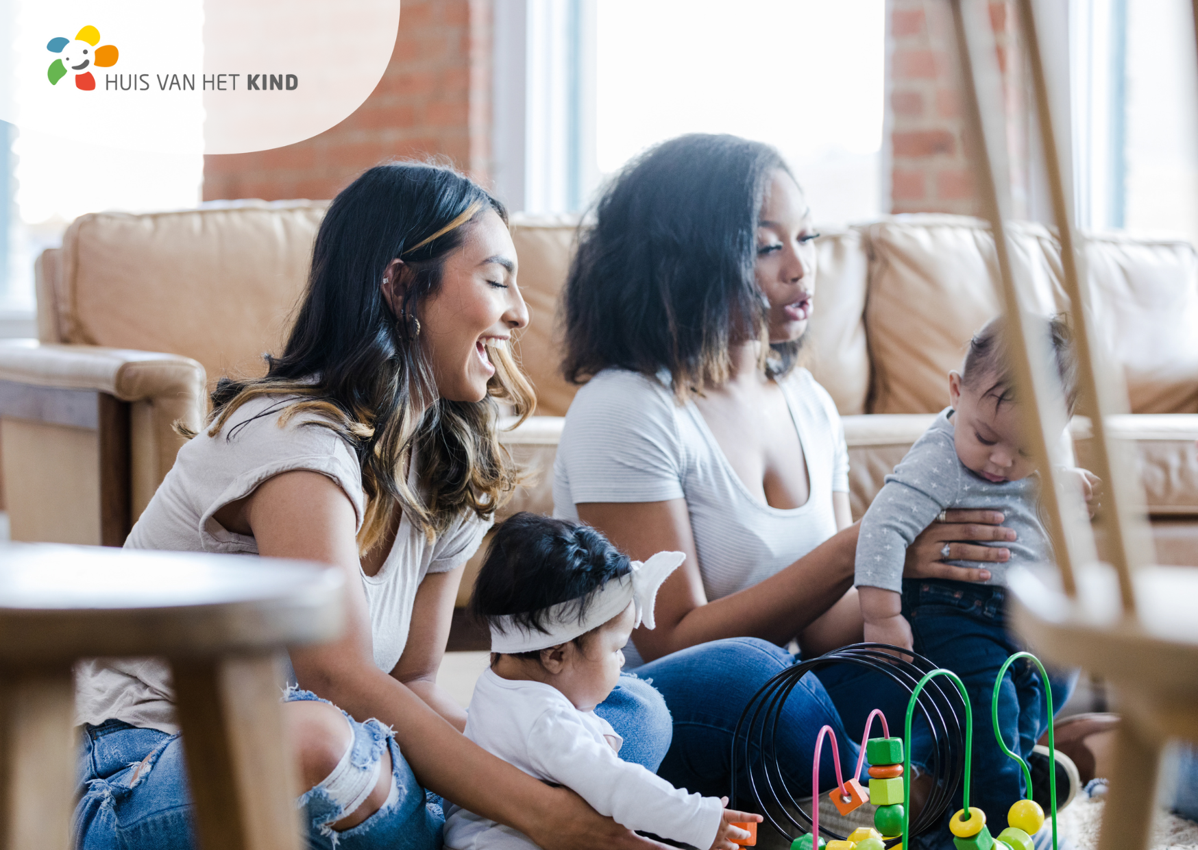 Twee mama's met hun peuters lachen en spelen