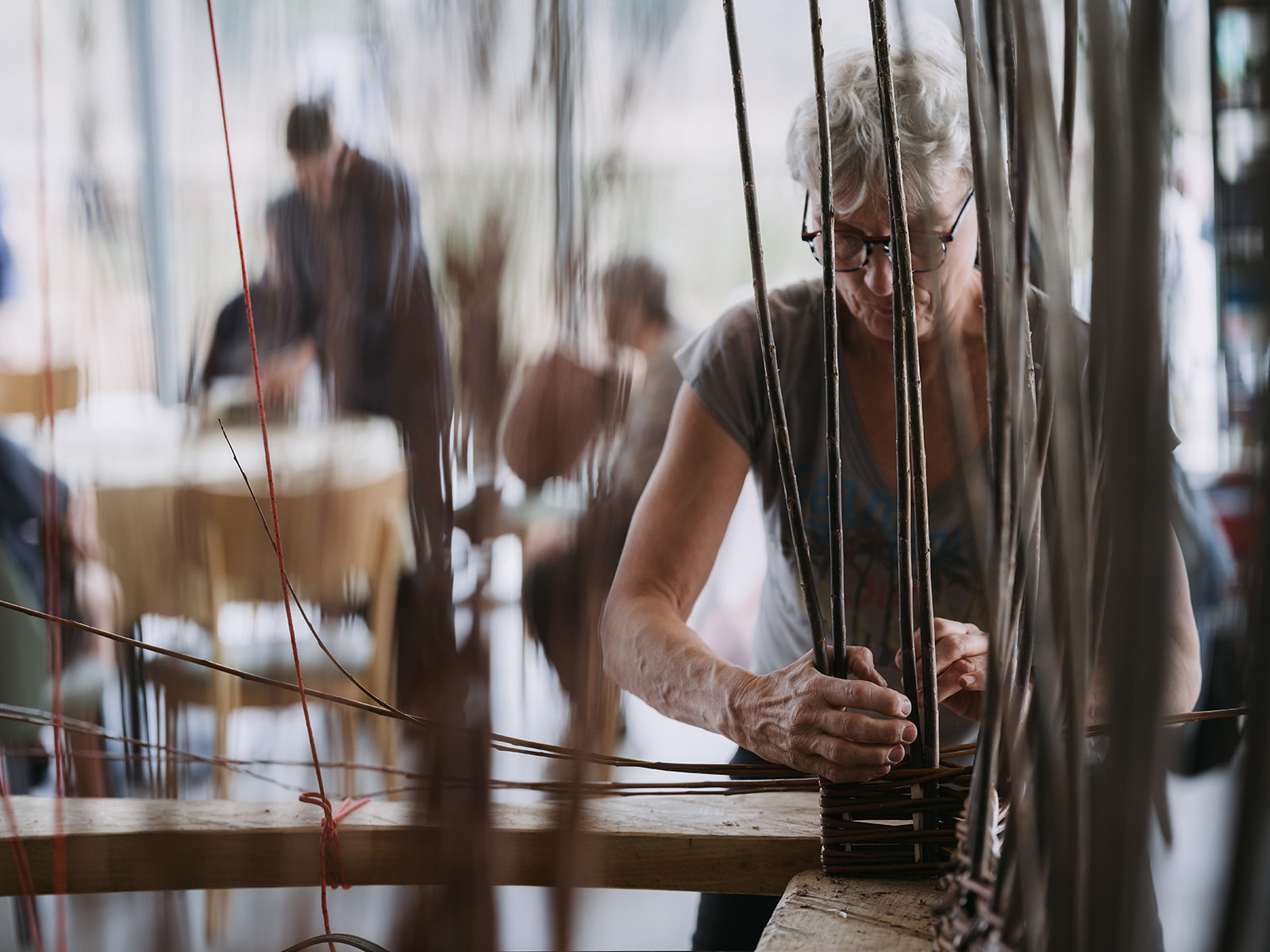 Iemand vlecht met wilgentakken een stuk van een huifkar