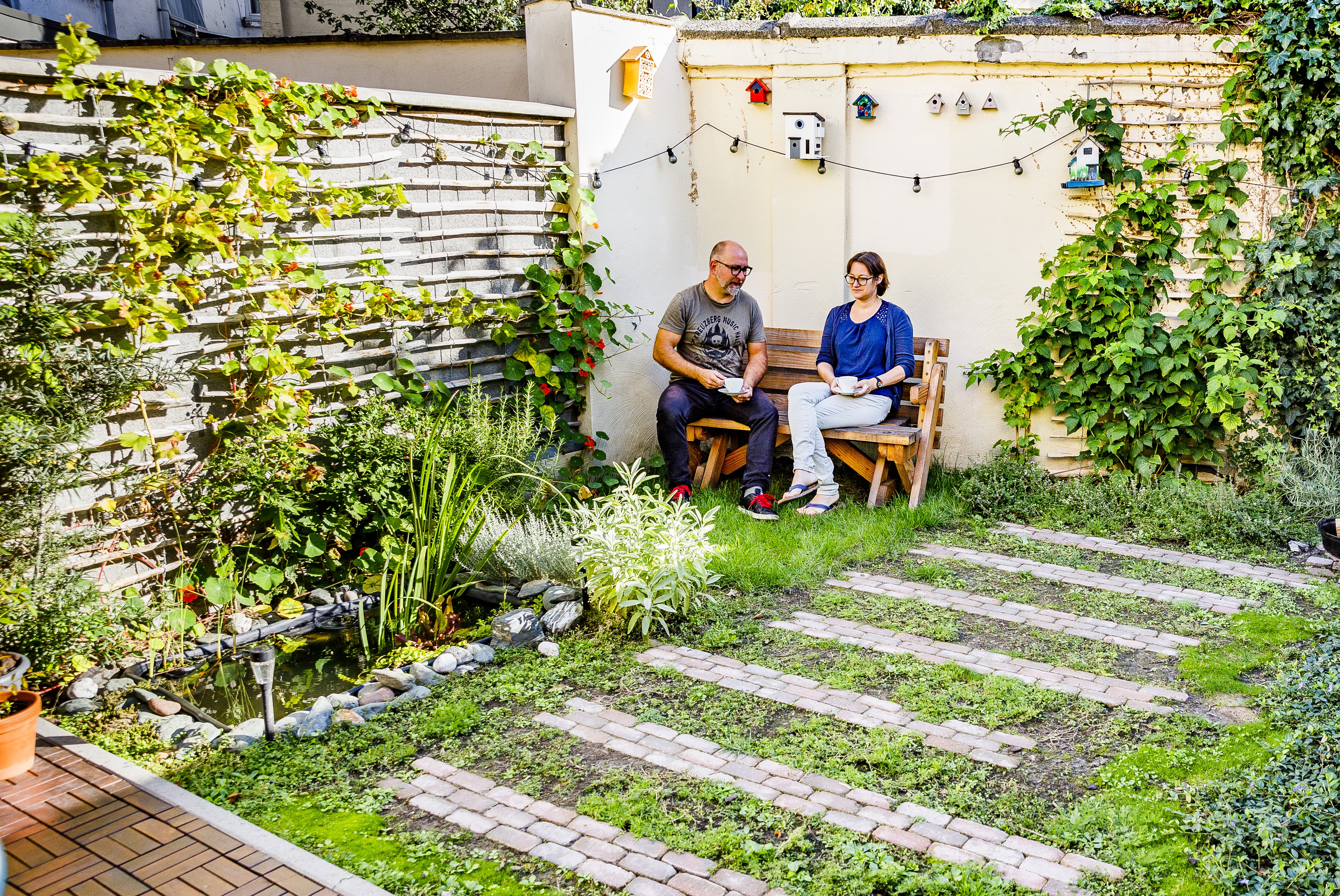 Koppel zit op een bank in een kleine stadstuin.