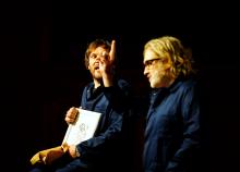 Afbeelding van 2 mensen die naast elkaar zitten en met elkaar praten.