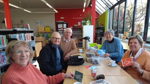 Mensen geven een complimentenkaart aan elkaar of zichzelf tijdens een gezellige babbel.