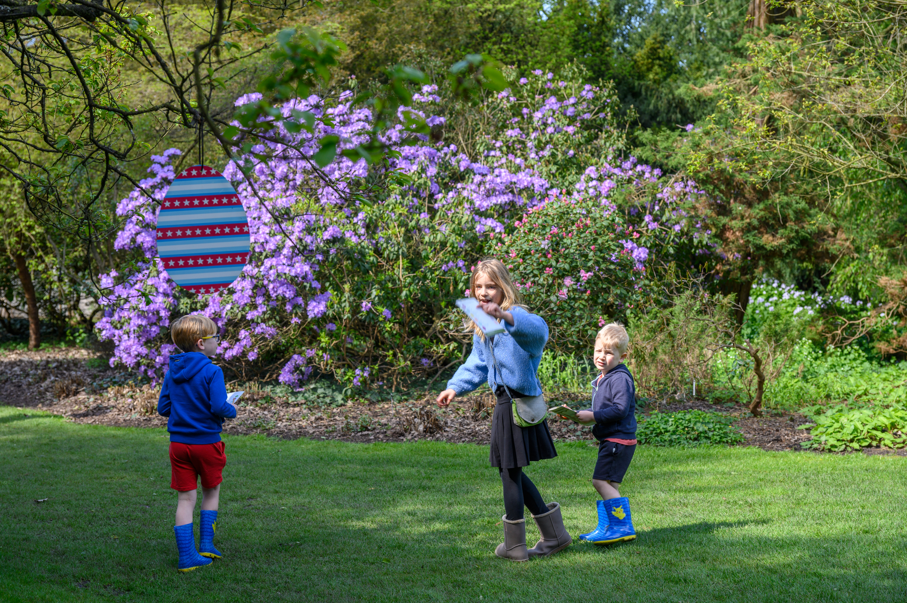 kinderen in de tuin met paasei dat in de boom hangt