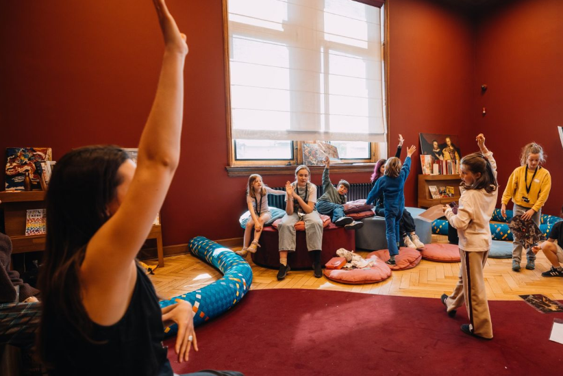 De kinderen steken hun handen in de lucht en doen actief mee met de voorstelling.