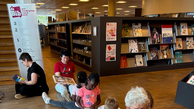 (groot)ouders en kinderen zitten rug aan rug en maken een voorleessling